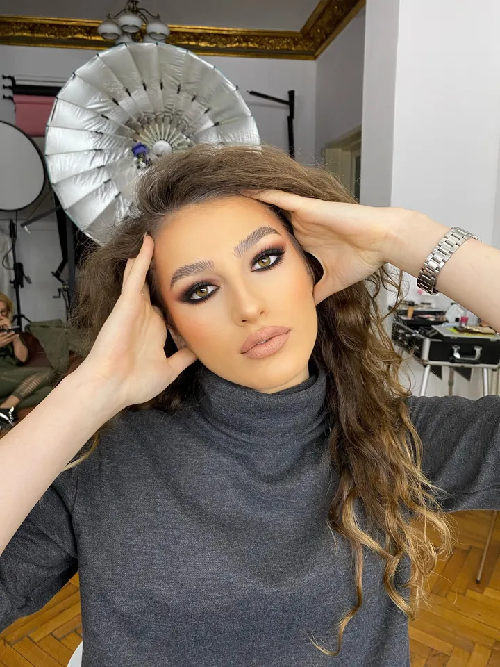 Machiaj de ocazie — ochi smokey intens și buze nude, privire frontală.